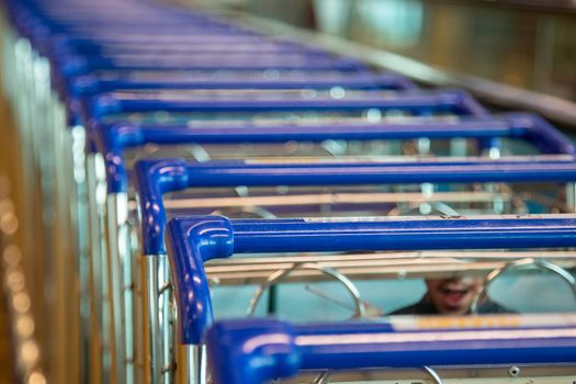 row of shopping trolleys close-up blue handles.