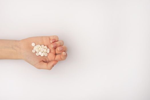 a handful of white pills in the palm of a close-up. on a white background. mock up