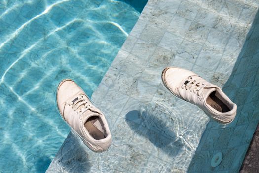 adult sneakers swim in the pool. shoe in swimming pool