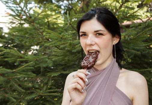 young brunette woman eating ice cream outdoor on summer day