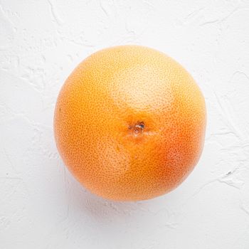 Fresh grapefruits set, square format, on white stone table background, top view flat lay