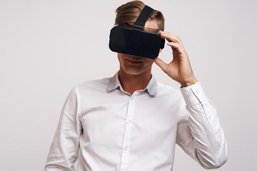 Cheerful man virtual reality glasses high-tech simulator technology studio. High quality photo