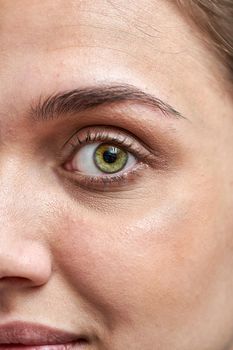 Close up of a beautiful female eye and a processed eyebrow, macro shot