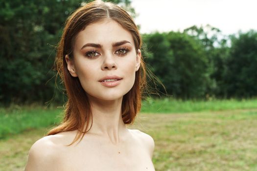 beautiful woman in a field outdoors bare shoulders clear skin cropped view. High quality photo