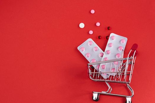 trolley with medicines on a red background Pharmaceuticals pills. High quality photo