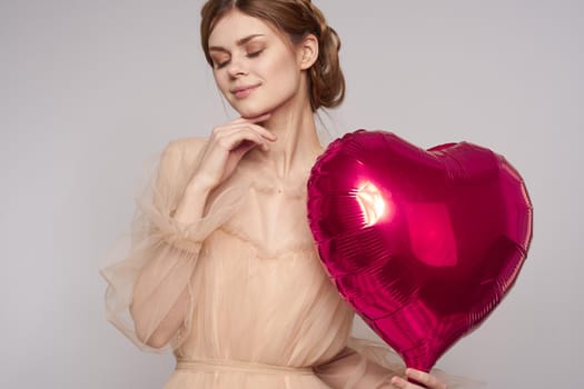 pretty woman red heart in the hands of the balloon isolated background. High quality photo