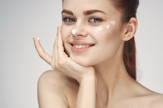 woman with face cream naked shoulders cosmetics face care. High quality photo