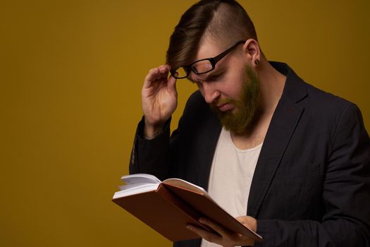 bearded man in a black jacket with a book in his hands education. High quality photo