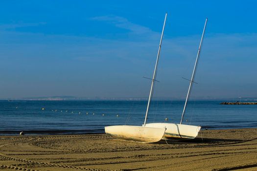 Beautiful sailboats on the shore on Levante beach in Santa Pola, Alicante, Spain