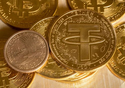 Concept of Tether coin against golden bitcoin coins and a single US dollar coin. Tether is backed by US dollar and used for trading in alt coins
