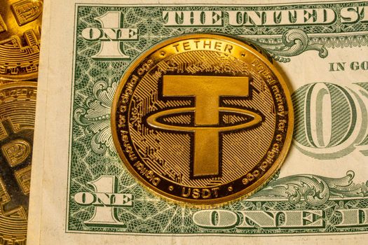 Concept of Tether coin against golden bitcoin coins and a single US dollar note or bill. Tether is backed by US dollar used for trading in alt coins
