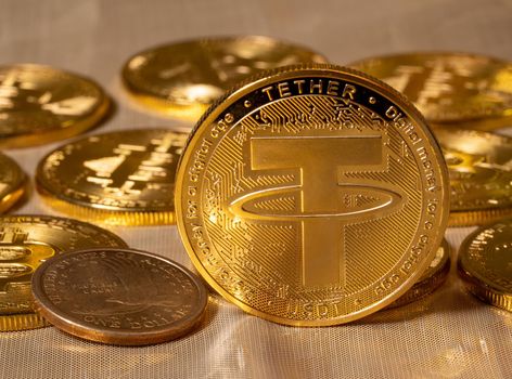 Concept of Tether coin against golden bitcoin coins and a single US dollar coin. Tether is backed by US dollar and used for trading in alt coins