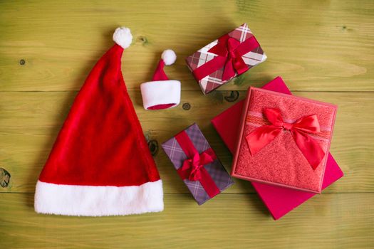 Image of Santa Hat and gifts on wooden table.