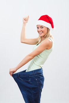 Portrait of happy woman with Santa hat in oversize jeans.