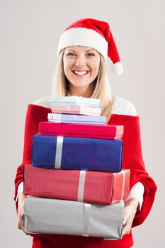 Portrait of beautiful woman with Santa hat holding bunch of gifts.