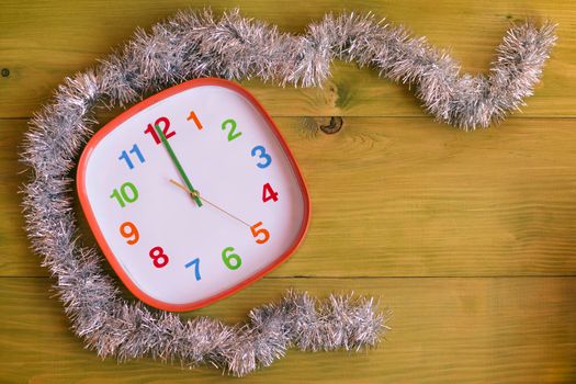 Image of decorated clock showing midnight  on wooden table.