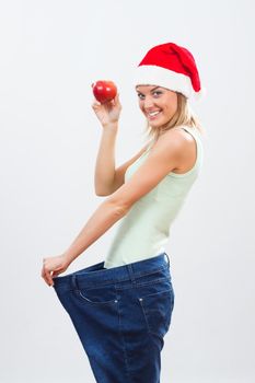 Happy woman in oversize jeans holding apple.