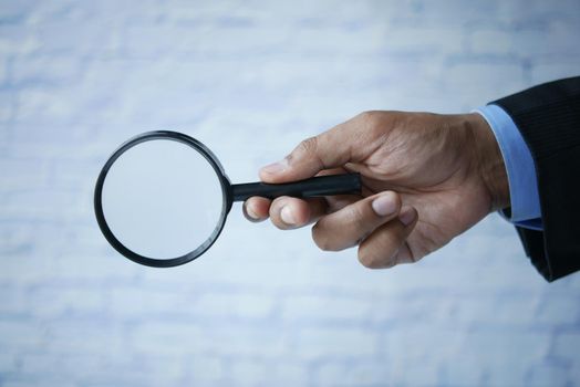 businessmen hand hold a magnifying glass .