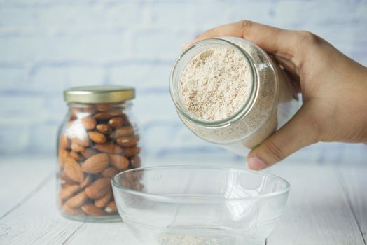 almond powder and almond in a jar on table