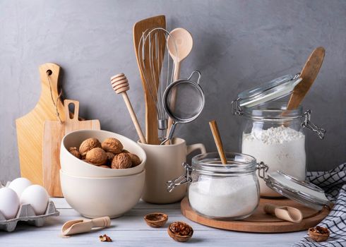 Close-up of kitchen utensils and containers made of wood, metal and glass. Ingredients for baking pie. Eco-friendly materials, no plastic concept. Selective focus.