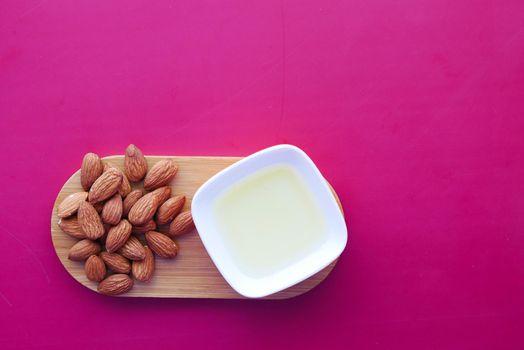 Almond oil in bottle on wooden background