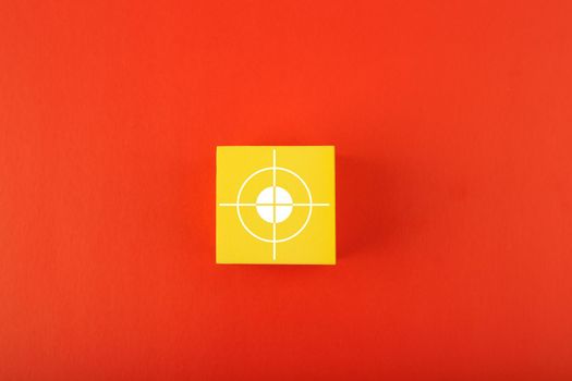 Goal symbol on yellow cube in the middle of red background. Concept of goal, success, reaching business and personal aims