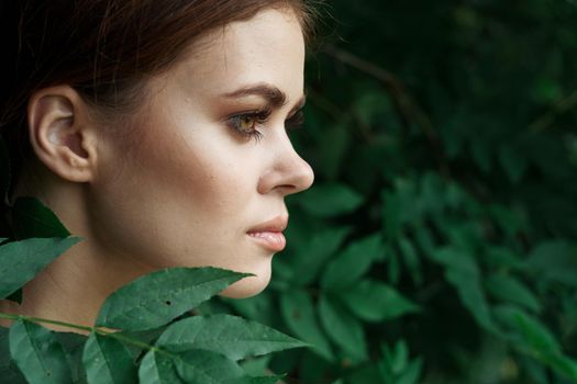 portrait of a woman Cosmetology nature green leaves glamor close-up. High quality photo