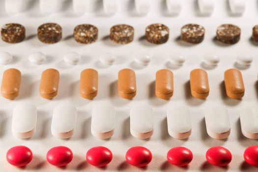 Rows of a variety of prescription medication pills close-up abstract