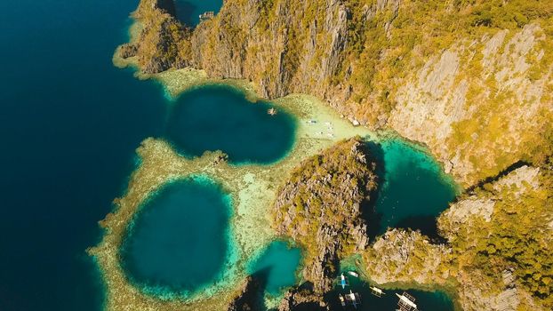 Aerial view: Twin Lagoon with blue, azure water in the middle of small islands and rocks. Beach, tropical island, sea bay and lagoon, mountains with forest, Palawan, Coron. Busuanga. Seascape, tropical landscape. Philippines. Travel concept