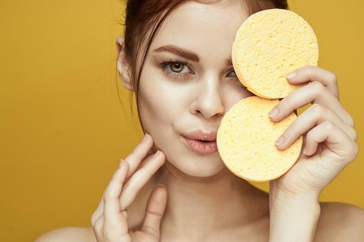 pretty woman with sponges in her hands bare shoulders clean skin hygiene. High quality photo