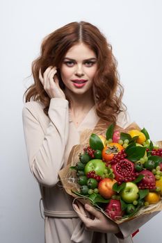 pretty woman smile posing fresh fruits bouquet emotions light background. High quality photo