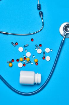 multicolored pills vitamins capsules medicine blue background. High quality photo
