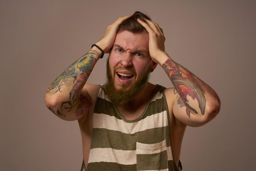 handsome man with tattoos on his arms fashionable hairstyle emotions. High quality photo