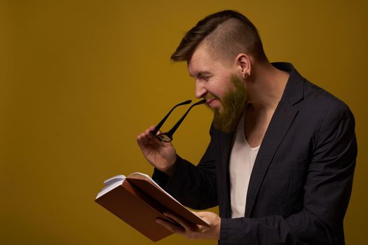 bearded man in a black jacket with a book in his hands education. High quality photo