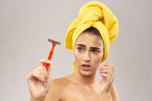 pretty woman with a yellow towel on his head shaving Lifestyle. High quality photo