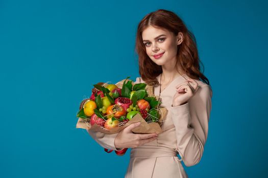 portrait of a woman beige coat fruit bouquet in hands colorful background. High quality photo