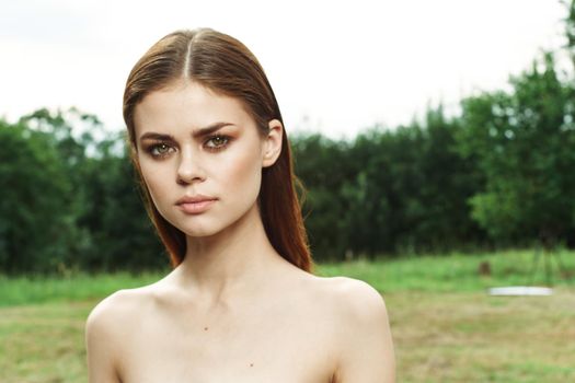 portrait of a woman in a field outdoors bare shoulders clear skin close-up. High quality photo