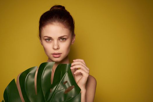 pretty woman bare shoulders red lips posing yellow background. High quality photo