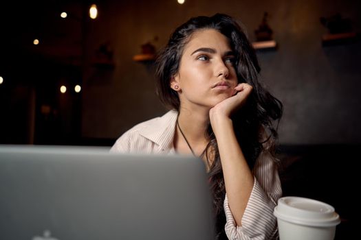 cheerful woman sitting in a cafe in front of a laptop communication internet lifestyle. High quality photo