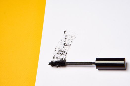 cosmetics mascara brushes decoration accessories yellow background. High quality photo