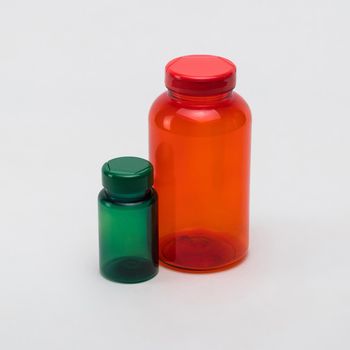 Multi colored transparent plastic pill jars on a white background. Isolated