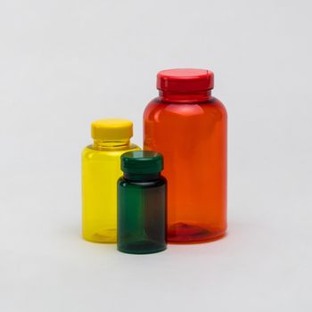 Multi colored transparent plastic pill jars on a white background. Isolated