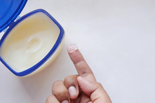 Close up of man hand using petroleum jelly .