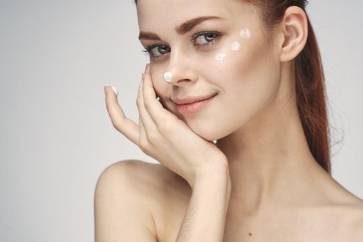 woman with face cream naked shoulders cosmetics face care. High quality photo