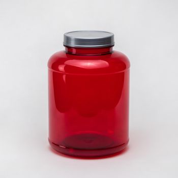 Large red transparent plastic pill jar on white background. Isolated
