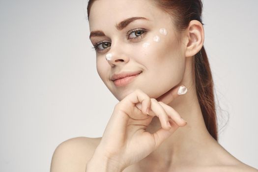 woman with face cream naked shoulders cosmetics face care. High quality photo