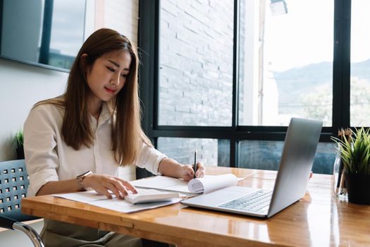 Business woman doing accounting with calculator and paperwork, financial adviser working.