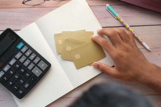 top view of young man hand hold credit card on table .