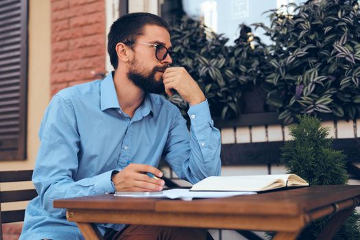 business man with papers in a summer cafe work communication. High quality photo