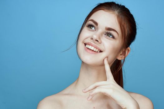 woman with bared shoulders pigtail emotions posing blue background. High quality photo